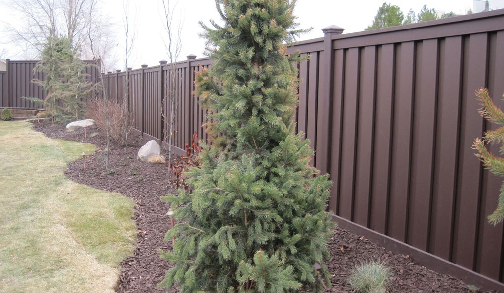Residential fence staining Ontario - professional brown stained wood fence with landscaping