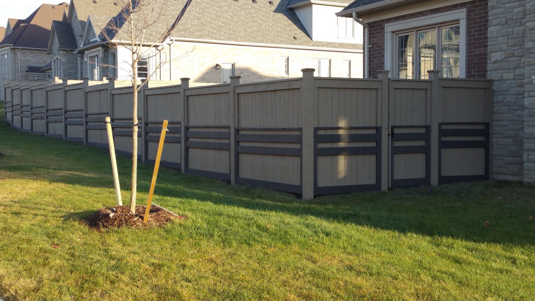 Residential fence staining Vaughan Toronto - two-tone gray and brown fence